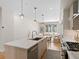 Kitchen island featuring pendant lights, a stainless steel dishwasher and hardwood floors at 4917 Lowell Blvd # 105, Denver, CO 80221