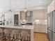 Bright kitchen boasts stainless appliances, light wood cabinetry, and a large island with seating at 4917 Lowell Blvd # 105, Denver, CO 80221