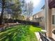 Large backyard with retaining wall, mature trees, green lawn, and seating area offering a private outdoor retreat at 6583 W Gould Dr, Littleton, CO 80123