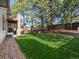 Spacious backyard with lush green lawn, mature trees, a second-story deck and patio, ideal for outdoor relaxation at 6583 W Gould Dr, Littleton, CO 80123