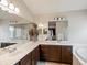 Large bathroom with dual sinks, marble countertops, and a view into bedroom at 6583 W Gould Dr, Littleton, CO 80123