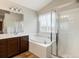 Bright bathroom featuring soaking tub, stand up shower and dual sink vanity at 6583 W Gould Dr, Littleton, CO 80123