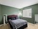 Cozy bedroom featuring green walls, plush bedding, window, and two mirrors at 6583 W Gould Dr, Littleton, CO 80123