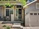 Inviting front entry showcasing brick accents, a secure storm door, and well-manicured landscaping at 6583 W Gould Dr, Littleton, CO 80123