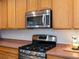 Close up on a modern gas range with a stainless steel microwave and light colored cabinets at 6583 W Gould Dr, Littleton, CO 80123