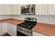This kitchen features stainless steel appliances, white cabinets, and updated countertops at 6583 W Gould Dr, Littleton, CO 80123
