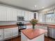 Bright kitchen features white cabinetry, stainless steel appliances, island and wood flooring at 6583 W Gould Dr, Littleton, CO 80123