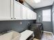 Well-lit laundry room with gray walls, plenty of counter space and storage cabinets at 6583 W Gould Dr, Littleton, CO 80123