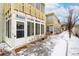 A multi-unit residential building with enclosed patios is seen in a snowy exterior shot at 655 S Clinton St # 2A, Denver, CO 80247