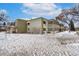 A multi-unit residential building with enclosed patios is seen in a snowy exterior shot at 655 S Clinton St # 2A, Denver, CO 80247