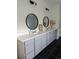 Bright bathroom featuring double vanity with sleek countertop, twin round mirrors, and modern fixtures at 6332 E 142Nd Pl, Thornton, CO 80602