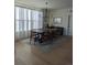 Elegant dining room with a large wooden table, modern lighting, and sheer curtains at 6332 E 142Nd Pl, Thornton, CO 80602