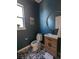 Stylish powder room with dark blue walls, decorative floors, and modern fixtures at 6332 E 142Nd Pl, Thornton, CO 80602
