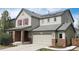 Inviting two-story home with solar panels, attached two-car garage, and manicured landscaping at 961 Stanley Ct, Erie, CO 80516