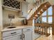 Stylish bar area with wine rack, sink, and granite countertop, complemented by a view of the staircase at 13452 Riley Peak Rd, Conifer, CO 80433