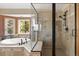 Modern bathroom featuring a soaking tub, glass shower, and tile flooring at 13452 Riley Peak Rd, Conifer, CO 80433