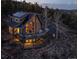 Stunning mountain home with a wrap-around deck, walls of windows, and solar panels, nestled in a serene wooded setting at 13452 Riley Peak Rd, Conifer, CO 80433