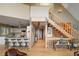 Open floor plan with hardwood floors, staircase, and kitchen with breakfast bar, blending style and functionality at 13452 Riley Peak Rd, Conifer, CO 80433