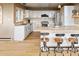 Bright kitchen featuring white cabinets, stainless steel appliances, granite countertops, and breakfast bar seating at 13452 Riley Peak Rd, Conifer, CO 80433