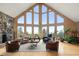 Bright living room boasts soaring windows, hardwood floors, stone fireplace and ample seating at 13452 Riley Peak Rd, Conifer, CO 80433