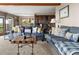 Bright living room features comfortable blue couches, wood floors, and plenty of natural light at 13452 Riley Peak Rd, Conifer, CO 80433