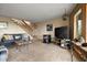 Cozy living room with carpet, couch, entertainment center, pellet stove, and staircase at 13452 Riley Peak Rd, Conifer, CO 80433