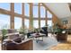Bright living room boasts soaring windows, hardwood floors, stone fireplace and ample seating at 13452 Riley Peak Rd, Conifer, CO 80433