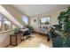 Bright home office with wood floors, a wooden desk, and large windows offering scenic views at 13452 Riley Peak Rd, Conifer, CO 80433