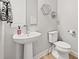Powder room with pedestal sink, modern fixtures, neutral paint and decor at 3293 Offbeaten Pl, Castle Rock, CO 80108