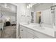 Bathroom with dual sinks, bright lighting, and open doorway to bedroom at 3293 Offbeaten Pl, Castle Rock, CO 80108