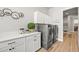 Modern laundry room with stainless steel appliances and ample counter space at 3293 Offbeaten Pl, Castle Rock, CO 80108