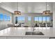 Open floor plan showcasing stylish pendant lights, a modern sink, and beautiful views from large windows at 3293 Offbeaten Pl, Castle Rock, CO 80108