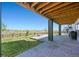 Covered patio features a stone surface, wood beam ceiling, and backyard view at 3293 Offbeaten Pl, Castle Rock, CO 80108