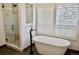 Luxurious bathroom with a freestanding tub, walk-in shower, and shuttered windows at 2162 Terraridge Dr, Highlands Ranch, CO 80126