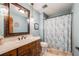 Charming bathroom features a classic vanity, decorative mirror, and shower with patterned curtains at 2162 Terraridge Dr, Highlands Ranch, CO 80126