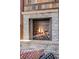 Close-up of stone fireplace with burning logs and decorative stone at 2162 Terraridge Dr, Highlands Ranch, CO 80126