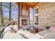 Inviting covered patio with stone fireplace, wood accents, and comfortable seating at 2162 Terraridge Dr, Highlands Ranch, CO 80126
