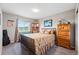 Cozy bedroom featuring a large window with a view, a bed, and wooden dressers at 2511 Loon Ln, Castle Rock, CO 80104