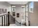 Upstairs hallway area with decorative lighting, multiple windows, and dark wood accents and railing at 2511 Loon Ln, Castle Rock, CO 80104