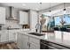 Bright kitchen boasts white cabinets, stainless appliances, and a large island with sink at 2511 Loon Ln, Castle Rock, CO 80104