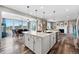 Modern kitchen island with white countertops, pendant lighting, and a sink, next to the dining and living spaces at 2511 Loon Ln, Castle Rock, CO 80104