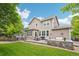 A spacious backyard features a stone patio with dining and seating areas, perfect for outdoor gatherings at 17020 E 107Th Ave, Commerce City, CO 80022