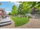 The landscaped backyard boasts lush green grass, river rock details, and a wooden fence for privacy at 17020 E 107Th Ave, Commerce City, CO 80022