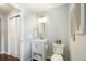 Well-lit half bathroom with white vanity, framed mirror, neutral walls, and dark wood flooring at 17020 E 107Th Ave, Commerce City, CO 80022