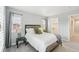A calming bedroom features neutral gray walls, plush carpet, and a stylish bed with rustic wood accents at 17020 E 107Th Ave, Commerce City, CO 80022