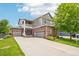 Beautiful two-story home featuring brick and siding, a three-car garage, and covered porch with a well-manicured lawn at 17020 E 107Th Ave, Commerce City, CO 80022