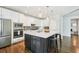 Bright kitchen featuring stainless steel appliances, a large center island with bar stool seating and pendant lighting at 17020 E 107Th Ave, Commerce City, CO 80022