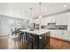 Open-concept kitchen with a large island, pendant lights, stainless steel appliances, and hardwood floors at 17020 E 107Th Ave, Commerce City, CO 80022