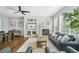 Inviting living room with a fireplace, built-in shelving, and large windows, creating a warm and welcoming atmosphere at 17020 E 107Th Ave, Commerce City, CO 80022