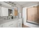 Bright bathroom features double sinks, shower/tub combo, white cabinetry, and tiled shower at 22580 E Ontario Dr # 204, Aurora, CO 80016